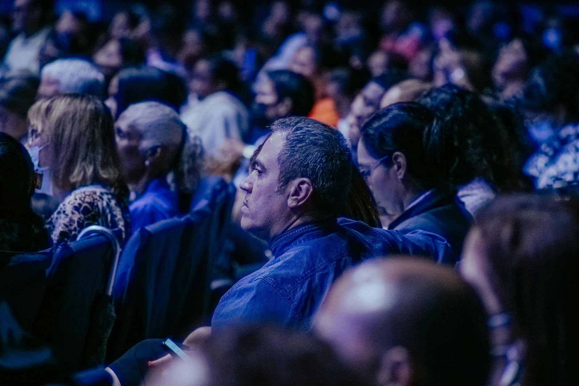 Zróżnicowana publiczność słucha prelekcji podczas wydarzenia w sali