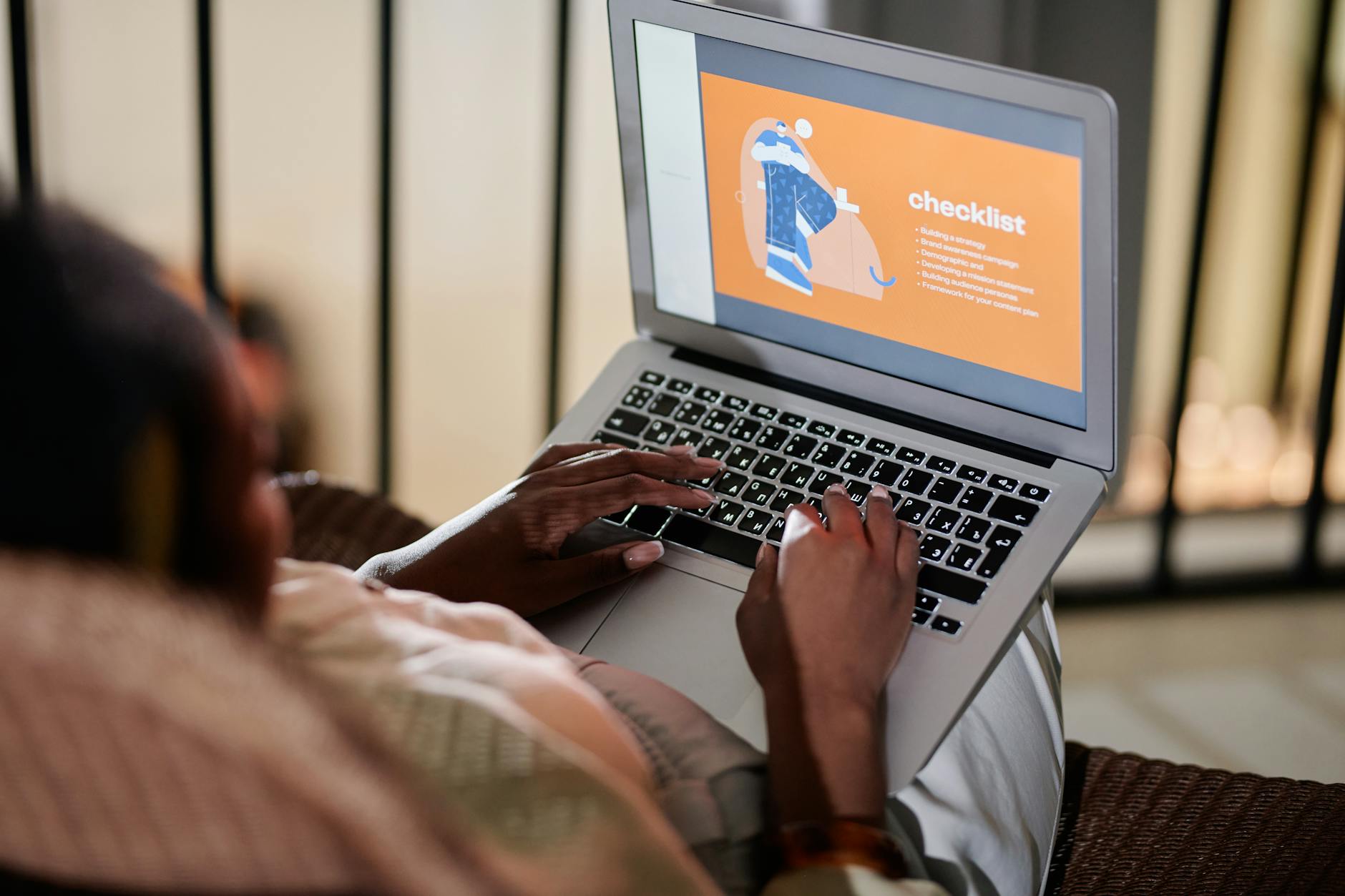 Osoba wypełniająca checklistę online na laptopie w plenerze